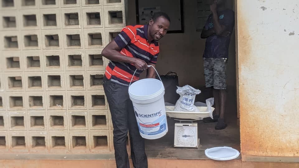 Man receiving a bucket of chlorine for water purification