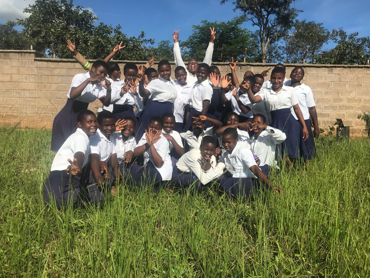 Students in Malawi celebrating outside their school
